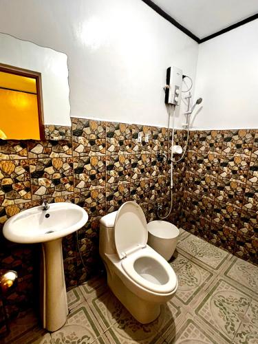 a bathroom with a toilet and a sink at Jewel Tourist Inn in Coron