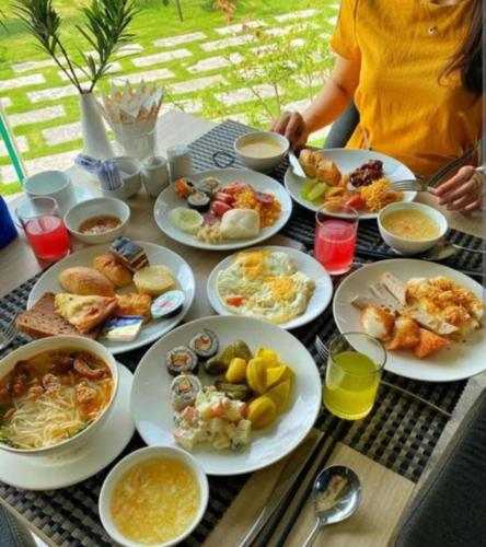 a table filled with plates of food on a table at Aloha Hotel Quy Nhơn in Quy Nhon