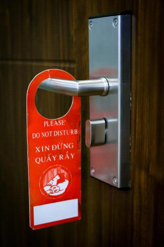 a doorhandle with a do not disturb sign on it at Aloha Hotel Quy Nhơn in Quy Nhon