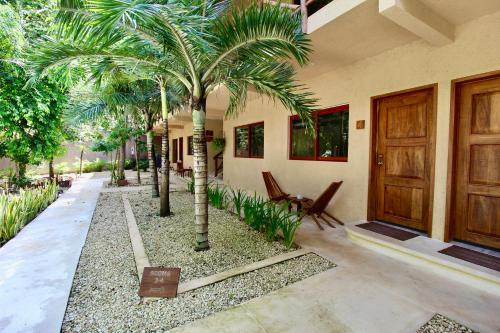 a house with a palm tree in a courtyard at Aldea Xaan Ha Tulum in Tulum