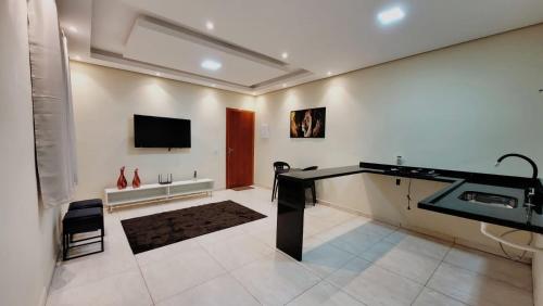 a bathroom with a sink and a tv on the wall at Apartamento Aparecida Rone 2 in Aparecida