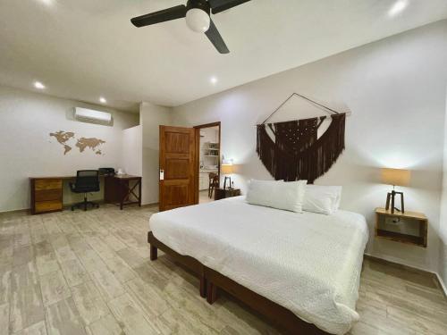 a bedroom with a bed and a desk and a ceiling fan at Aldea Xaan Ha Tulum in Tulum