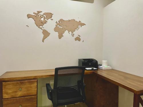 a desk with a chair and a world map on the wall at Aldea Xaan Ha Tulum in Tulum