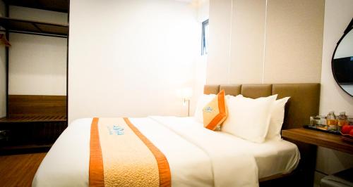 a bedroom with a large white bed with a window at Aloha Hotel Quy Nhơn in Quy Nhon