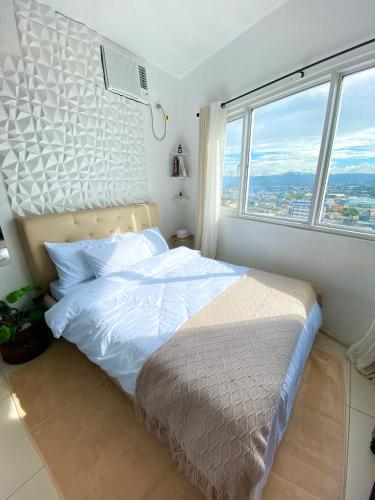 a bedroom with a bed with a large window at Fully furnished condo in Quezon City in Manila