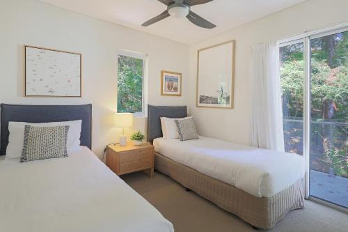 una camera da letto con due letti e una finestra di The Cove Noosa - Apartment 19 a Noosa Heads