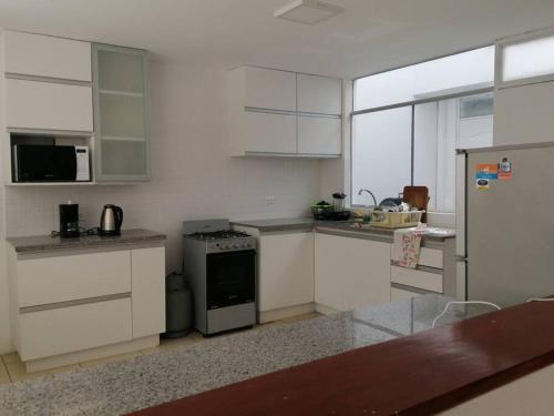 a kitchen with white cabinets and a stove at J&B Aparment 1 Punta Hermosa in Punta Hermosa