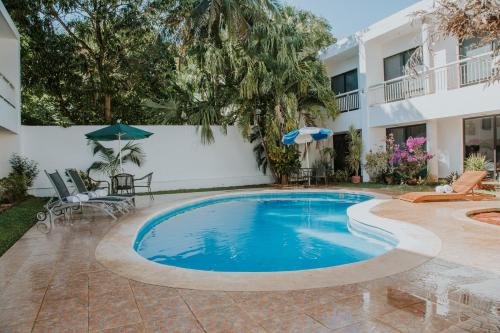 a swimming pool in front of a building at Hotel Holly in Mérida