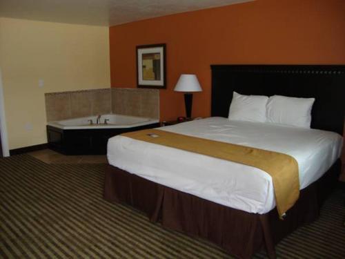 a hotel room with a bed and a bath tub at Montigo Inn in Leesville