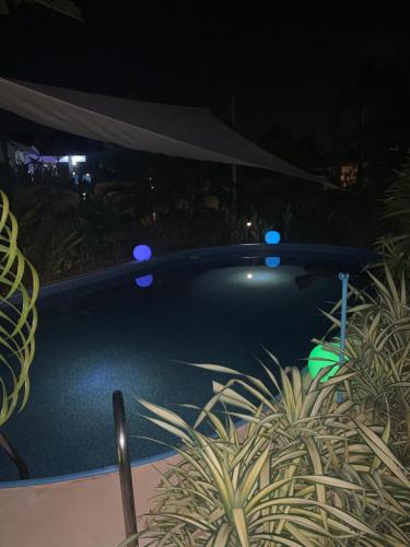 a swimming pool at night with blue lights at Baan Bettina Haus 1 in Ban Chak Phai