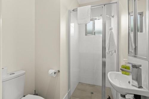 Cable Beach的住宿－Tiki's Pearl Villa Broome，白色的浴室设有卫生间和水槽。