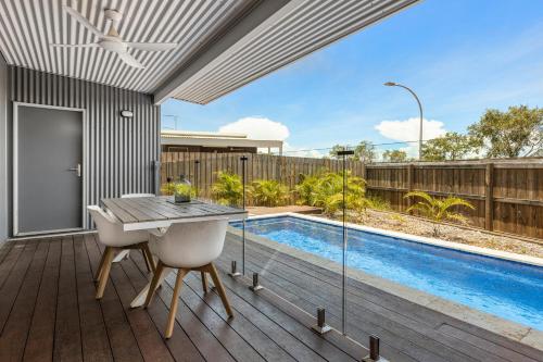 a patio with a table and a swimming pool at Tiki's Pearl Villa Broome in Cable Beach