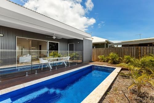 a backyard with a swimming pool and a house at Tiki's Pearl Villa Broome in Cable Beach