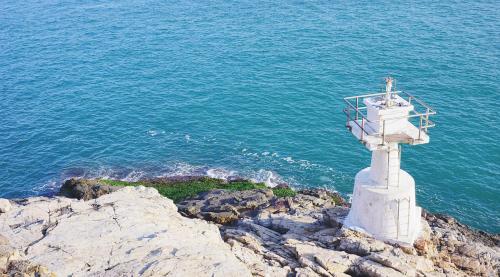 a white lighthouse on a cliff near the ocean at Urbanwood Ap Lei Chau in Hong Kong