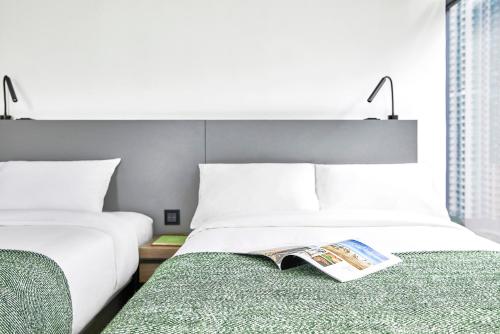 a hotel room with two beds and a magazine on the bed at Urbanwood Ap Lei Chau in Hong Kong