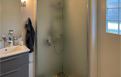 una ducha con una puerta de cristal junto a un lavabo en 3 Bedroom Cozy Home In Arboga, en Findla