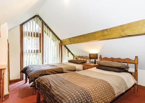 1 dormitorio con 2 camas y ventana en Exmoor Gate Lodges en Chipstable