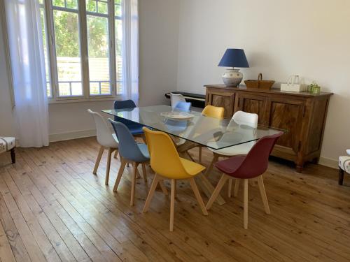 une salle à manger avec une table et des chaises colorées dans l'établissement Superbe Villa Spacieuse avec Jardin et Pétanque, Idéale pour Familles à Arcachon - FR-1-374-33, à Arcachon
