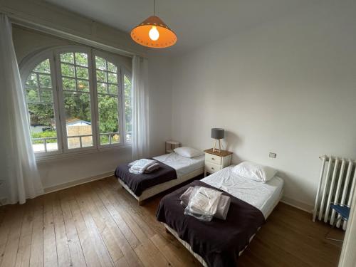 deux lits dans une chambre avec une grande fenêtre dans l'établissement Superbe Villa Spacieuse avec Jardin et Pétanque, Idéale pour Familles à Arcachon - FR-1-374-33, à Arcachon