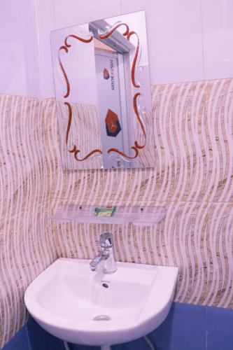 a bathroom with a sink and a mirror at Hotel National Park- A peaceful Family home where you can stay Peace and Enjoy and Organize the wildlife Safari in Chitwan