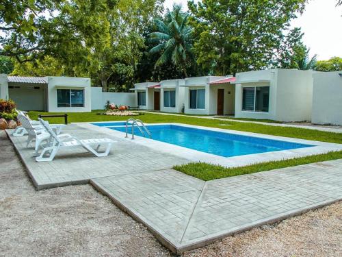- une piscine avec une chaise et une maison dans l'établissement HOTEL ISLA, à Isla Aguada