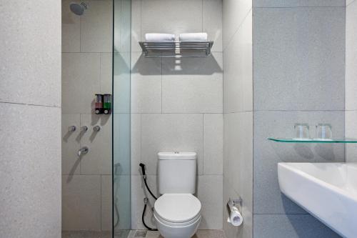 Amaris Hotel Kalimalang في جاكرتا: حمام مع مرحاض ومغسلة ودش