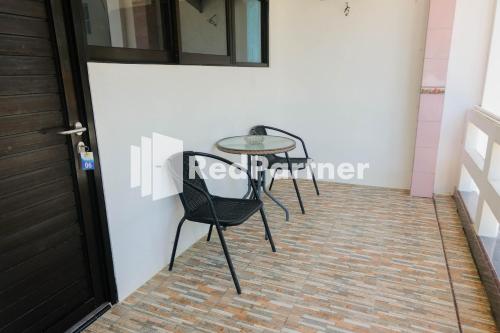 einen Tisch und Stühle neben einer Tür in der Unterkunft Ken Zong Inn Hotel in Cijaringao