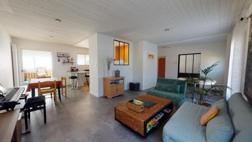 un salon avec un canapé et une table dans l'établissement Coucher de soleil proche de la mer, à Saint-Hilaire-de-Riez