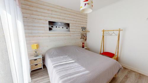 une chambre avec un lit et une télévision sur un mur dans l'établissement Coucher de soleil proche de la mer, à Saint-Hilaire-de-Riez