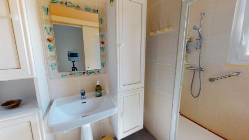 une salle de bain avec un lavabo et une douche dans l'établissement Coucher de soleil proche de la mer, à Saint-Hilaire-de-Riez