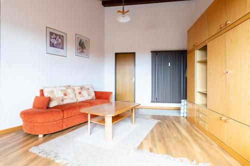 ein Wohnzimmer mit einem roten Sofa und einem Tisch in der Unterkunft Ferienwohnpark Immenstaad am Bodensee Maisonette-Wohnung 53 27 in Immenstaad am Bodensee