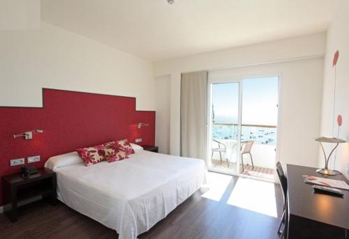 a bedroom with a white bed and a red wall at Hotel Embarcadero de Calahonda de Granada in Calahonda