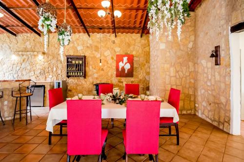 a dining room with a table and red chairs at Montana Zurqui in San José de la Montaña