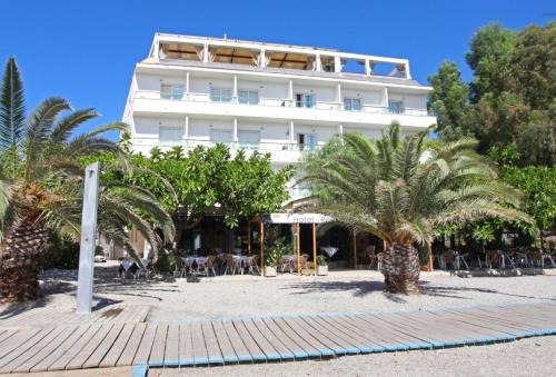 a large white building with palm trees in front of it at Hotel Embarcadero de Calahonda de Granada in Calahonda