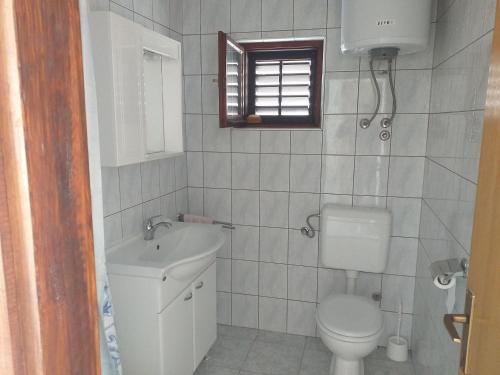 La salle de bains est pourvue de toilettes et d'un lavabo. dans l'établissement Apartment Moonstone, à Metajna