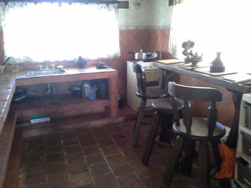 cocina con mesa, sillas y fregadero en Villa Sofia, en Fúquene