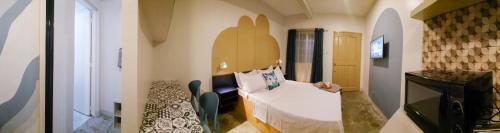 um pequeno quarto com uma cama e uma secretária em Hive Manila Guesthouse and Apartments 400 Mbps - Gallery Studio em Bacoor