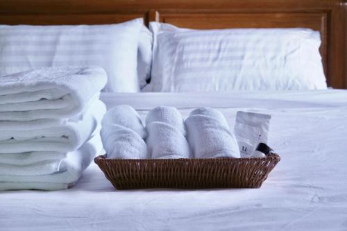 een mand met handdoeken en handdoeken op een bed bij LANNA HOUSE บ้านลานนา เชียงดาว in Chiang Dao