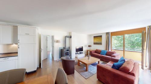 a living room with two couches and a table at Walensee House & Apartments in Unterterzen