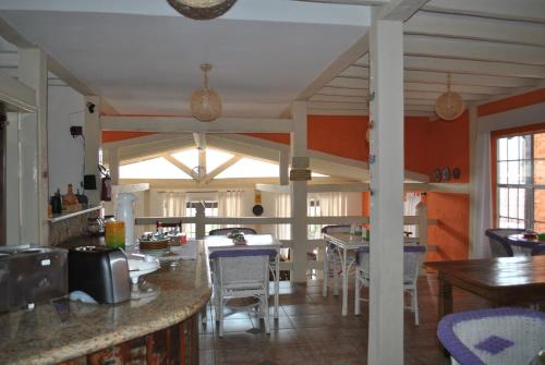 eine Küche und ein Esszimmer mit Tischen und Stühlen in der Unterkunft Pousada Ananda-ri in São Lourenço