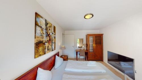 a hotel room with a bed and a tv at Walensee House & Apartments in Unterterzen