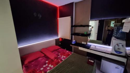 a small room with a bed and a mirror at Aeropolis by AT ROOM in Teko