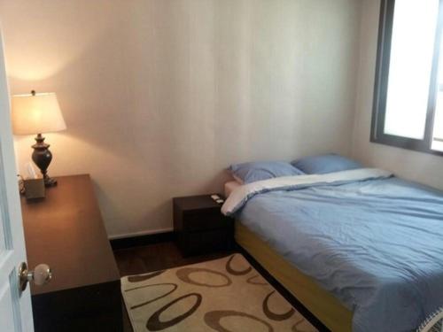 a bedroom with a bed and a table and a lamp at Ramnant Guest House in Ulsan