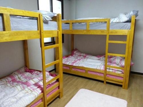 2 Etagenbetten in einem Zimmer mit einem Zimmer mit in der Unterkunft Ramnant Guest House in Ulsan