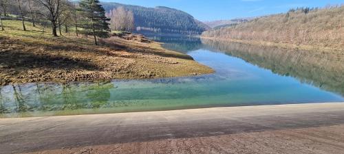 a body of water next to a road next to a river at Cocoon in Stavelot
