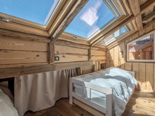 a bedroom in a wooden house with a large skylight at Appartement Méribel, 3 pièces, 4 personnes - FR-1-613-1 in Méribel