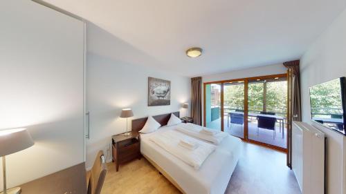 a bedroom with a bed and a large window at Walensee House & Apartments in Unterterzen