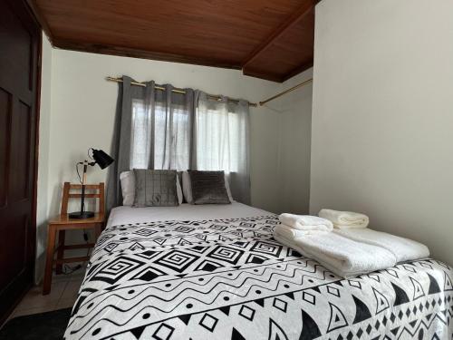 a bedroom with a black and white bed with a window at Tiny apartment in the city rooftop terrace in Baños