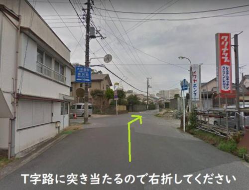an empty street with a yellow arrow on the road at 宿いちのみや in Ichinomiya