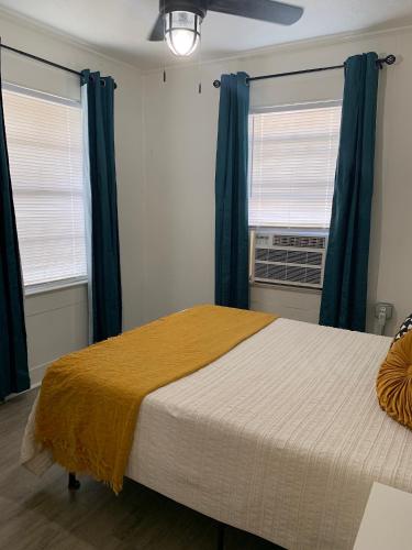 a bedroom with a large bed and two windows at The Haven in Brookhaven